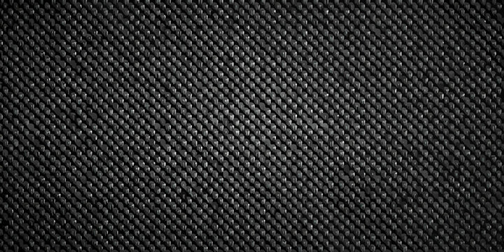 Close up of a dark textured surface resembling woven carbon fiber