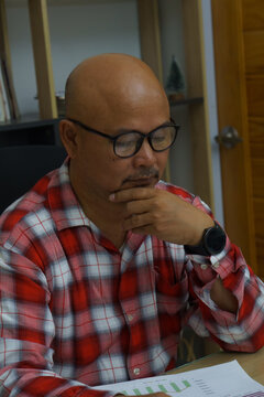 Stressed businessman, Frustrated and upset with business pressure and overworked at office. Adult Asian male working on laptop, feeling tire and headache. Stressed and Frustrated concept.