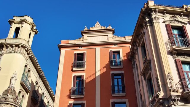 Historic building with ornate balconies and a religious statue on a corner of La Rambla in Barcelona, Spain
