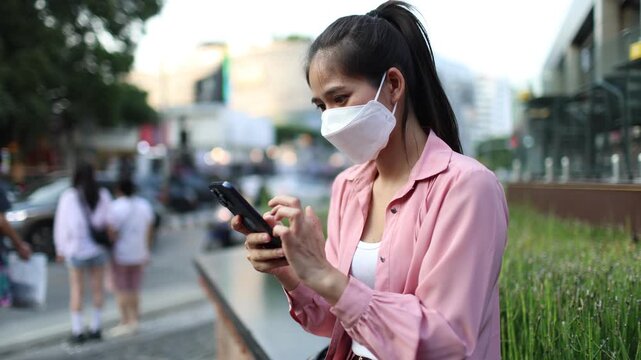 Person wearing mask in toxic urban air, monitoring pollution levels on device, highlighting health risks, environmental hazards, smog, and city pollution concerns.
