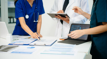 Doctors and nurses analyzing x-ray image on tablet for diagnosis, using digital technology in modern hospital, teamwork © laddawan