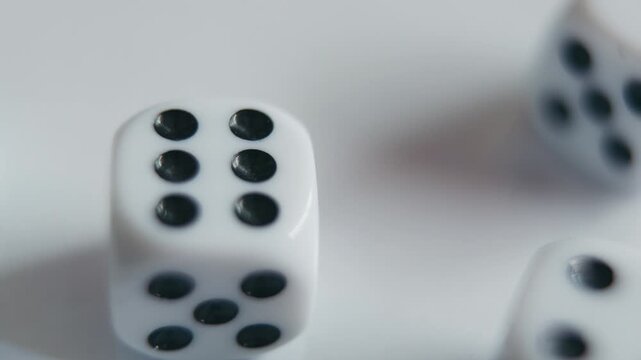 Rolling Multiple White Dice on White Surface