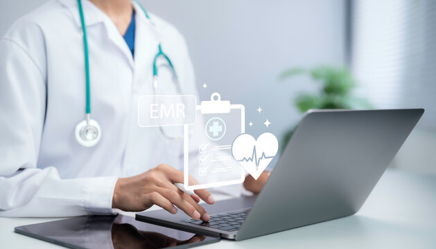 Doctor typing on laptop managing EMR electronic medical record system digital healthcare interface patient data entry clinical documentation smart clinic health information technology