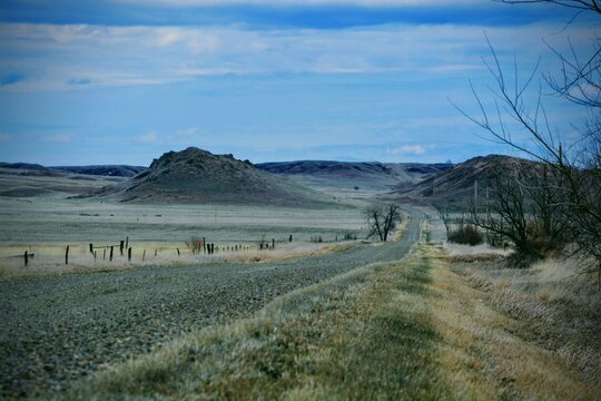 A gravel road meanders between rocky Montana hills