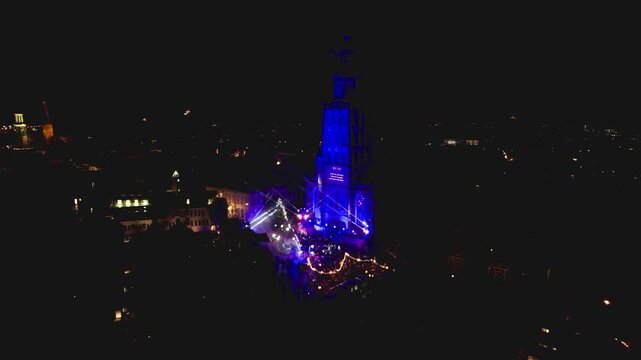 New Years Eve light show in Dutch tower town Zutphen, The Netherlands, with Walburgiskerk lit up by laser and spotlights with urban city center around lit up by streetlights