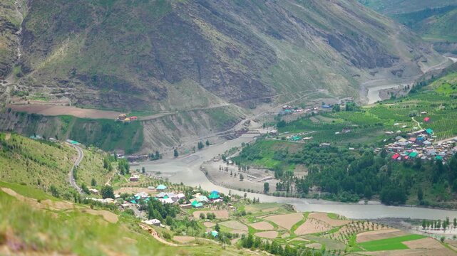 4K shot of villages on side of Chenab river as seen from nearby mountain at Lahaul in Himachal Pradesh, India. Tandi village on side of the ChandraBhaga confluence forming Chenab river in India.