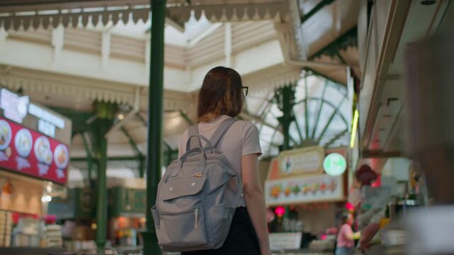 Woman looking at cafe window at Lau Pa Sat hawker center in Singapore, famous street food market and travel destination in Asia