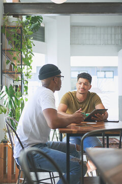 Team, talking and businessmen with tablet in cafe, content creation and planning for project on web. Coffee shop, remote work and people with digital assignment, video editing or discussion with tech