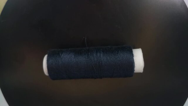 sewing thread spool rotating in top-down view with smooth motion and clean composition.