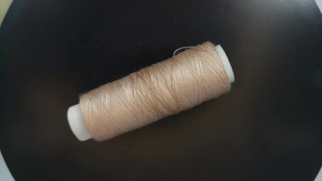 sewing thread spool rotating in top-down view with smooth motion and clean composition.
