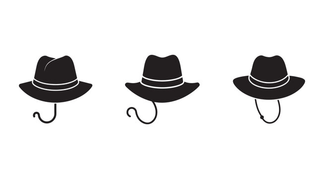 Three black hats with chin straps hanging on hooks  isolated on white background