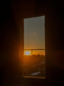 Beautiful golden sunset view through a dark window frame silhouette
