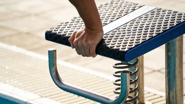 Hand gripping diving board edge