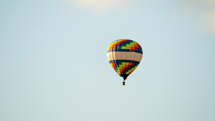 Fototapeta premium Single hot air balloon floats gently in the sky