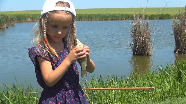 Child Studying a Fish Caught by Father, Girl Playing on a Fishing Lake, Kid at Pond