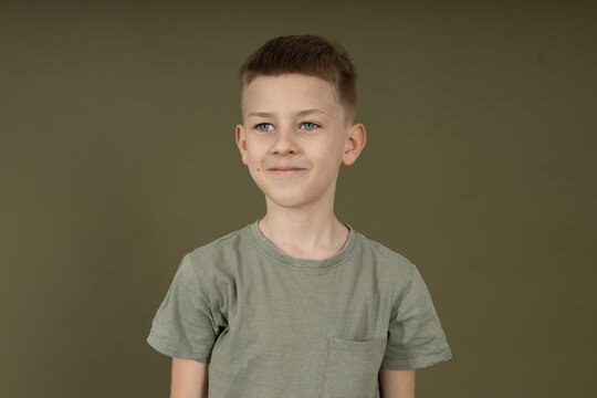 Young boy with skeptical look and hands on hips. Attitude, personality and confidence concept, studio portrait on neutral background.