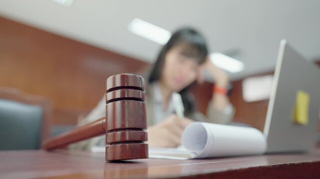 Close-up gavel with lawyer working behind, representing legal authority in corporate business. Concept of compliance, contracts, and professional legal services.