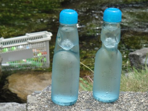 Japanese traditional soda Ramune bottles cooling by a clear river in summer, Shiga, Japan.