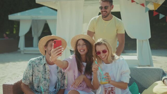 Group capturing cheerful beach photo, Candid photo of friends with drinks and accessories in tropical setting