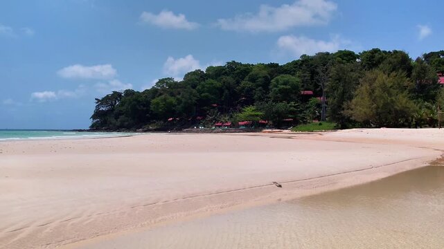 Drone footage of a tropical beach in Koh Rong, Cambodia. Featuring a paradisiac beach with white sand, turquoise waters, clear skies, and a town