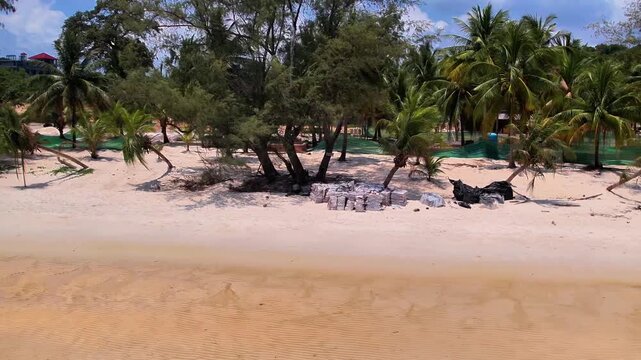 Drone footage of a tropical beach in Koh Rong, Cambodia. Featuring a paradisiac beach with white sand, turquoise waters, clear skies, and a town