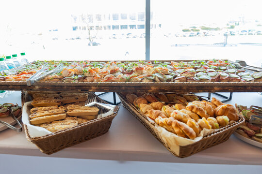 Catering with meats, fruits, cheeses and sandwiches. An assortment of cold cuts and canapes on wooden skewers