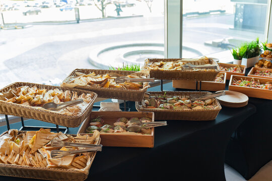 Catering with meats, fruits, cheeses and sandwiches. An assortment of cold cuts and canapes on wooden skewers