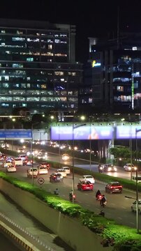 Busy evening road traffic in Cyber City, Gurgaon, India. Real time vertical motion video.
