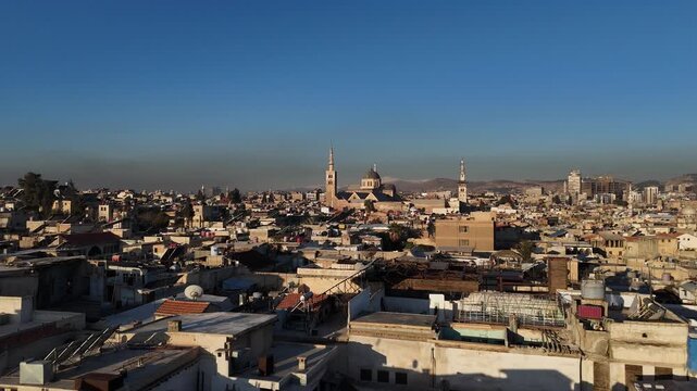 drone vista over the historic rooftops and minarets of Damascus, the capital of Syria at sunset