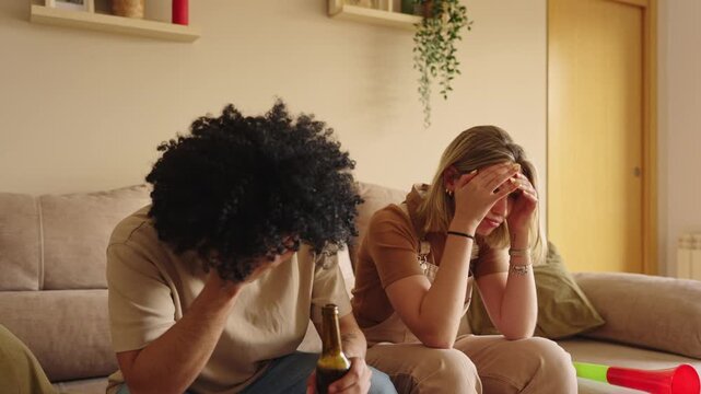 Football fans watching a match at home, reacting with disappointment to a missed penalty on tv