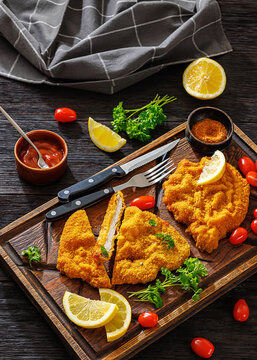 Crispy meat schnitzel served on wooden cutting board