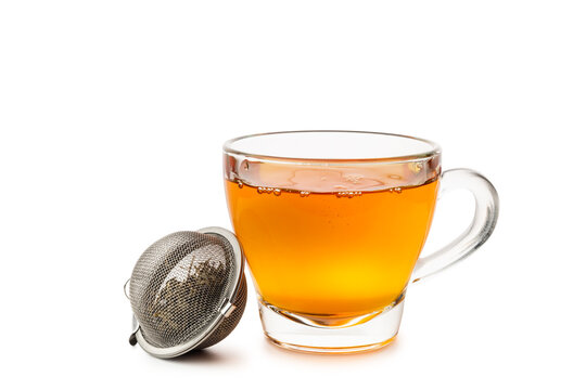 Glass cup of tea with metal tea infuser isolated on white background.