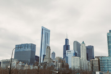 Naklejka premium City skyline of Chicago on a cloudy day with tall buildings and modern architecture in view from the ground
