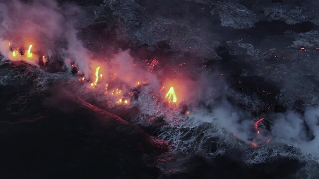 Aerial view of the fiery Piton de la Fournaise volcano spewing lava and smoke, a landscape of contrasting colors and textures, Piton de la Fournaise, Saint-Benoit, Reunion.