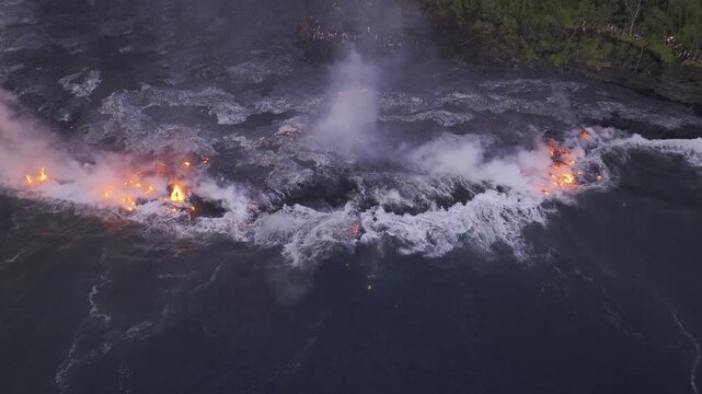 Aerial view of the glowing hot lava flowing from Piton de la Fournaise, contrasting against the dark landscape, Sainte Rose, Saint-Benoit, Reunion.