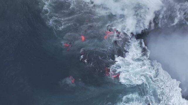 Aerial view of molten lava flowing into the ocean, creating a dramatic contrast of fire and water, Piton de la Fournaise, Sainte Rose, Reunion.