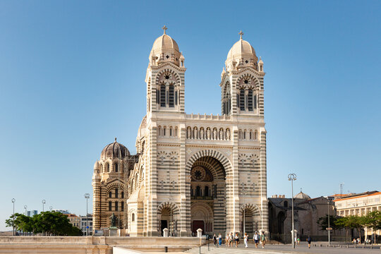 La Cathédrale de La Major &agrave; Marseille avec son parvis, vue de trois quart avant en contre-plong&eacute;e, format paysage, touristes se promenant sur la place, grand ciel bleu en arri&egrave;re-plan