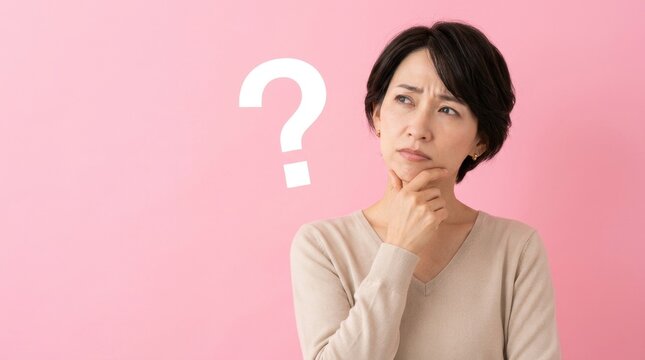 Thoughtful Asian woman pondering a difficult question with a large question mark on a vibrant pink background, symbolizing uncertainty, challenges, and decision-making.