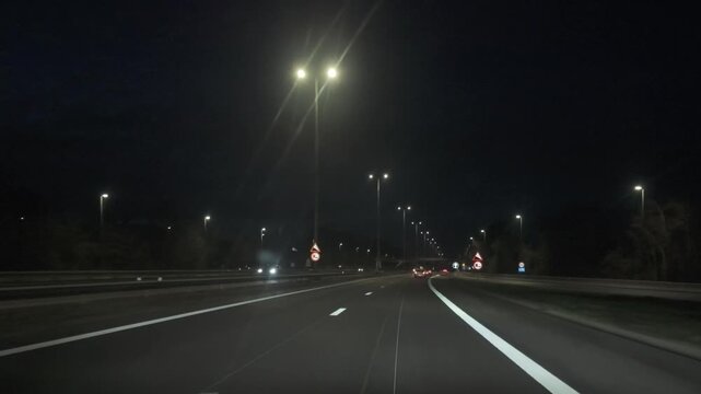 Point of View Driving on a Well-Lit Highway at Night