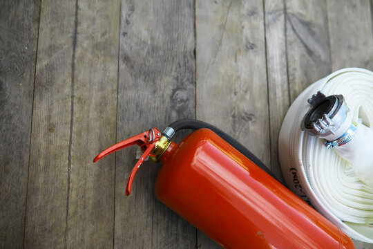 hand presses the trigger fire extinguisher available in fire emergencies conflagration damage background. Safety