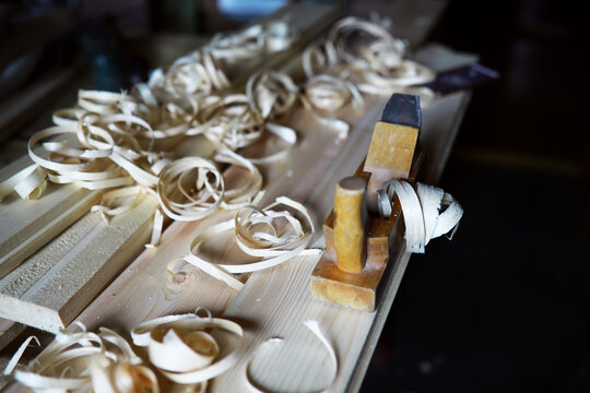 Plane jointer carpenter or joiner tool and wood shavings. Woodworking tools on wooden table. Carpentry workshop