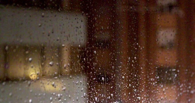 Rain Drops Sliding on Window Glass with Blurred City Background, Early Morning, No People
