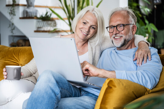 Couple relaxing at home using a notebook together on the couch