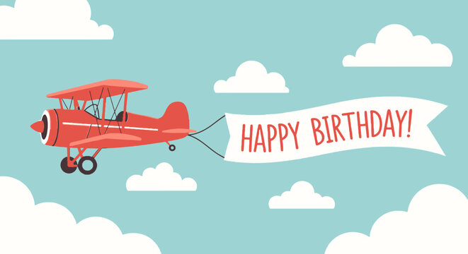 A red biplane flies across a light blue sky with white clouds, pulling a banner