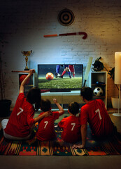 Family watching soccer match on TV at home and cheering for goal together. Concept of streaming service promotion, smart TV usage, home entertainment platform, and digital media consumption © master1305