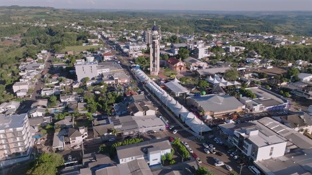 Ametista do Sul town center expands below as the drone ascends and tilts down, revealing the church tower and rolling hills, captured in D-Log with 10-bit color using a Hasselblad sensor.