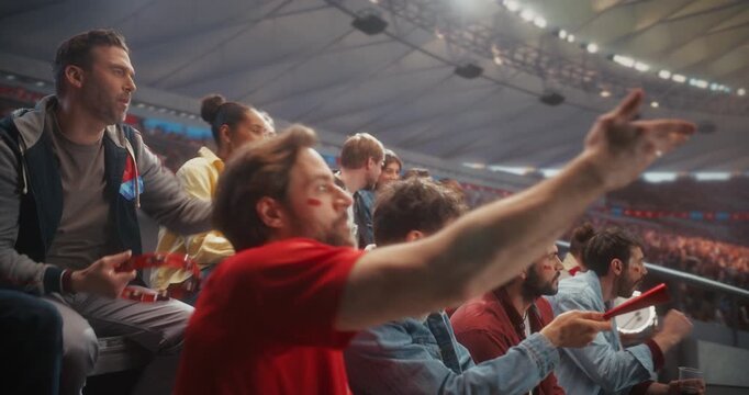 Diverse Stadium Fans Cheer Passionately for Their Soccer Team, Waving Scarves, Clapping, Pointing and Celebrating Together From the Stands During an Exciting Live Match on Euro Cup Arena