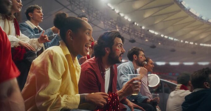 Multiracial Group of Fans in a Packed Stadium Cheer and Celebrate During Championship Game, Backing Their Team in a Professional Sport Arena as a Goal Score Sparks Joy at an International Match.