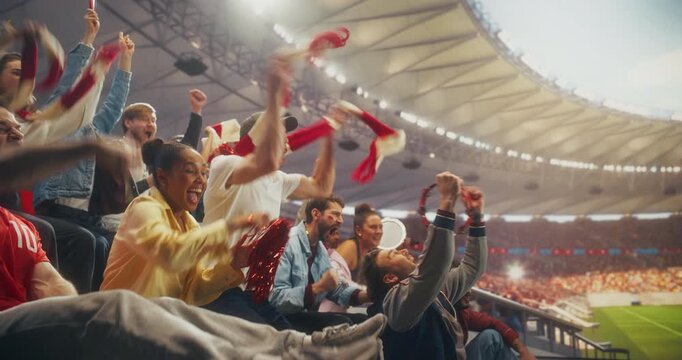 Diverse Fans in a Stadium Cheer and Celebrate a Soccer Goal During a Championship Sport Event, Supporting Team in a Packed Arena as a Professional League Match Turns Into a World Stage Triumph.