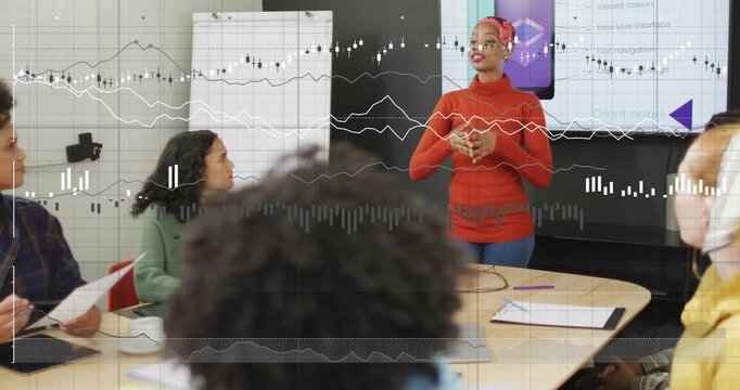 Presenter starting talk, stepping and gesturing as animated charts showing data in business meeting